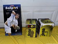 Photo of two boxes of Penn tennis balls and the box of a Tourna Ballport ball holder.