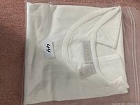 Folded white Ladies T-shirt with Lissom brand tag visible, size XS tag attached.