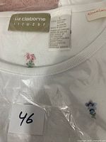Close-up photo of neckline showing Liz Claiborne label, material and size tag, and small embroidered floral details.