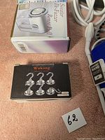 Sweater defuzzer box and Wukong magnetic hooks box on a pink fabric background