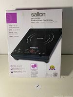 Front view of the Salton portable induction cooktop box showing product image and main features like 1800 watts power, energy efficient, safe and clean cooking.