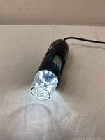 Front view of the digital zoom microscope showing the illuminated LED lights around the clear lens.