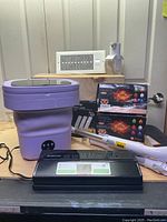 Group photo of all 8 household essential items on wooden surface against white panel wall.