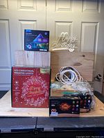 Full lot photo showing all light items including boxed Govee RGBIC outdoor lights, Christmas wreath lights, birthday sign, tea lights, fairy and rope lights