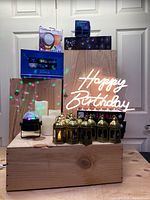 Photo showing most lot contents including mini LED strobe light, lanterns, faux wax candles, happy birthday sign, and flickering LED candles.