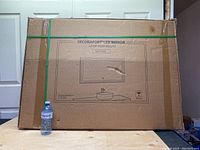 Closed cardboard box packaging of Decoraport LED mirror, 40x28 inch model D210-4028, with illustration of mirror mounted above sink and branding.