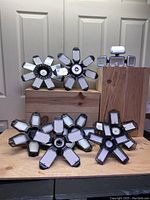 Front view showing eight LED light fixtures with petals of LED bulbs on each, arranged on wooden blocks.