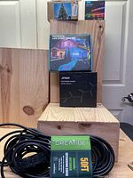Overview of all boxed items stacked including Greatide 50ft extension cord and various LED light products (Aneeway, Govee, Starllt)
