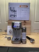 Full view of machine, milk tank, accessories and box on workbench