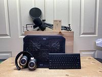 Lot showing the headphones, wireless keyboard, and laptop cooling mount with microphone stand on top.