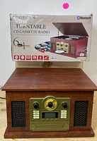 Photo of the boxed turntable system showing brand Proscan and Bluetooth logo, highlighting included 6-in-1 features.