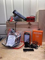 Digital Timing Light with attached clamps and cable, 400W Power Inverter, portable solar generator device with cables and plug adapters, sealed oil extractor accessories in plastic bag, digital multimeter box with accessories.