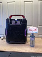 Front view of the black ION Pathfinder 320 with red handle, control panel, and water bottle for size reference