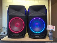 Two ION Total PA Extreme speakers side by side with LED rings lit pink and blue. Photo to show the pair and size reference.