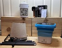 Lot of small household appliances and items including portable washing machine, floor lamp parts with shade, lint remover and portable fan.