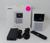 Emotn N1 projector alongside original packaging, remote control, power adapter and power cable