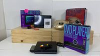 Overview of all items including DVD player with remote and cables, 10.1" tablet boxed, gold CD radio boombox with box, and DVD player box.