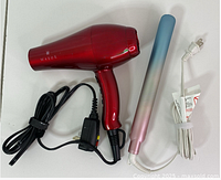 Hair dryer and hair straightener placed side by side on white surface showing cords and colors.
