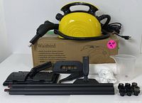 Full set with main unit placed on cardboard box plus all attachments and accessories lined out in front including mop head, extension rods, brushes, cloth, and measuring cup.