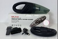 Handheld vacuum cleaner sitting on top of its box with crevice tool, brush attachment, USB charging cable, and extendable hose arranged alongside.