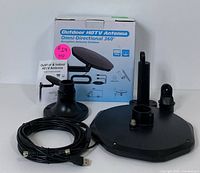 Box and all parts for the outdoor HDTV omni-directional antenna, including circular antenna, mounting bases, arm, and cable with connectors