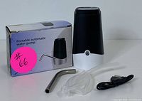 Portable automatic water dispenser with packaging box, showing the black and white main unit, stainless steel spout, clear tubing, and USB cable.