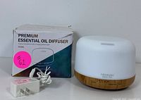 Photo of ASAKUKI essential oil diffuser with original packaging box and power adapter included.