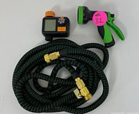 Full set of the garden hose, spray nozzle and timer laid out showing condition and components