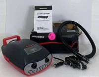 Electric air pump with hose, nozzle attachments, and user manual arranged on white surface.