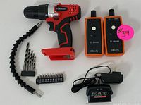 Full set including cordless power drill, drill bits, flexible extension, two wireless signal detectors, and battery charger with adapter.