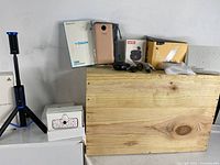 Overview of all items showing the selfie stick on a tripod stand, wireless earbuds in charging case, power banks, and wireless charger.