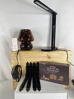 Photo of all items showing two lamps, four black vintage style shelving brackets, and a boxed furniture repair kit on a wooden surface.