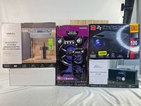 Photo showing all four boxed items in the lot, stacked side by side on a white background. Items are in original packaging, boxes indicate product types and brands.