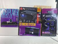 Front view of the boxed DVD Player, RCA 2-in-1 Home Theater Projector with bonus 100 inch theater screen, and CD Micro System.