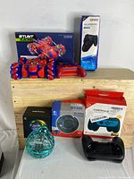 Overall view of the lot showing all items together including the remote control car and its box, the dual charging dock box, the flying star toy box, the flying ball toy, and the Switch grip with controller charging dock.