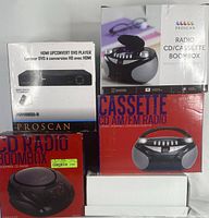 Boxed Proscan HDMI Upconvert DVD Player and three boxed Proscan Radio CD/Cassette Boombox units stacked