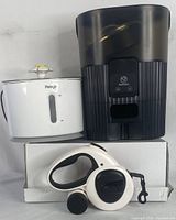Photo showing all three items: automatic pet feeder, pet fountain, and retractable leash arranged on a white box.