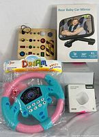 Grouping all lot items showing the driving toy, LED busy board, white noise machine, and packaged baby car mirror.
