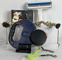 Three pet items: retractable double dog leash with ergonomic handle, reusable pet hair remover roller, and dog training collar remote and receiver box.