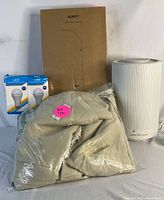 Lot contents showing Levoit air purifier, two LED bulbs in packaging, and packaged beige curtains.