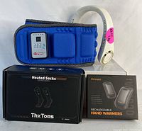 Photo shows body slimming belt, white neck fan, ThxToms heated socks box, and Ocoopa rechargeable hand warmers box.