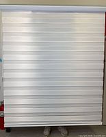 Zebra roller blind in fully opaque position showing solid white horizontal stripes covering the entire window area.