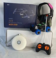 All four items displayed together: Chubury A68 Brushless Drone box, remote control car with controller, white noise machine, and shooting earmuffs.