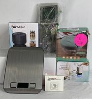 Full view of all items including kitchen scale, mason jar vacuum sealer box, food chopper box, digital thermometer probe wrapped in plastic, and humidity and temperature monitor with box