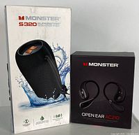 Box for Monster S320 Superstar Bluetooth speaker with waterproof design and Monster Open Ear AC210 Bluetooth headphones box side by side.