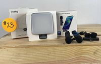 SmallRig Vibe P96 LED video light box, wireless lavalier microphone box, 2 clip-on microphones with foam covers, and added accessories arranged on light wood surface.