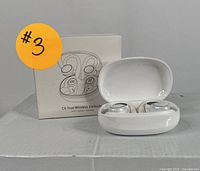 White C6 True Wireless Earbuds in charging case with original box behind, showing front view of earbuds and box front.