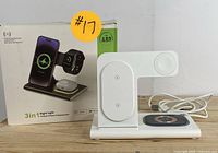 White wireless charging station with three zones for phone, watch, and earbuds, accompanied by original box showing product image.
