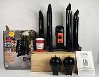 Full view of the boot and glove dryer with all components on a wooden base, original box on left, instruction manual, and glove drying attachments in front.