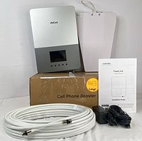 Full kit contents arranged: main booster, outdoor antenna, coax cable, power adapter, manual, and box